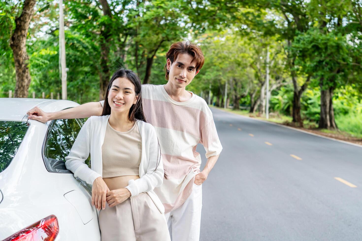 Young asian couple get out of the car and walk to enjoying the view, standing near the car, Man and woman looking at sunset and beautiful nature, Boy and girl standing by the machine photo