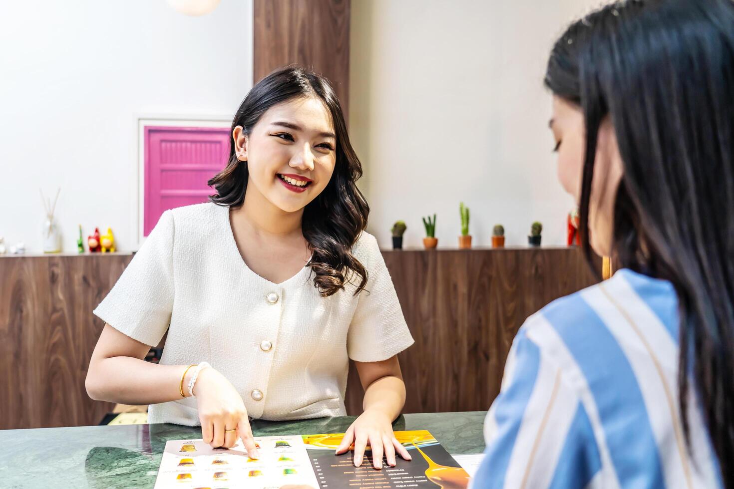 Young asian beautiful female customer select coffee or juice items. with a young woman barista working at the cafe or restaurants counter, entrepreneurial concept Starting a small business, lifestyle photo