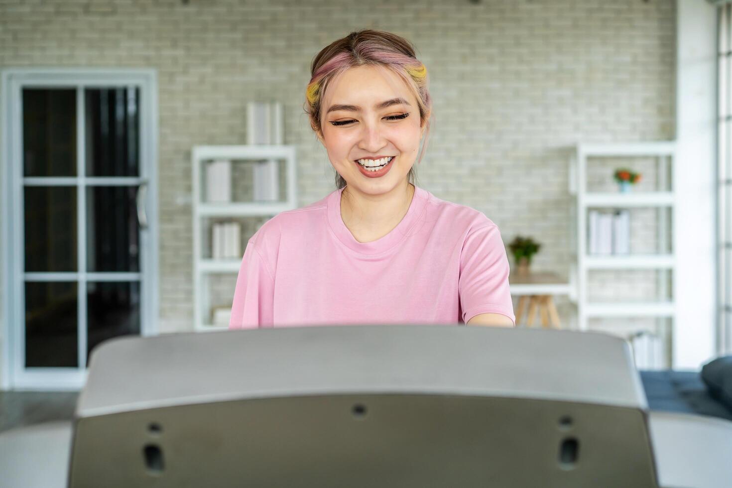 Beautiful asian girl smiles sweetly training fitness aerobics cardio exercises, Young people running on a treadmill in home,Sport and recreation concept. photo