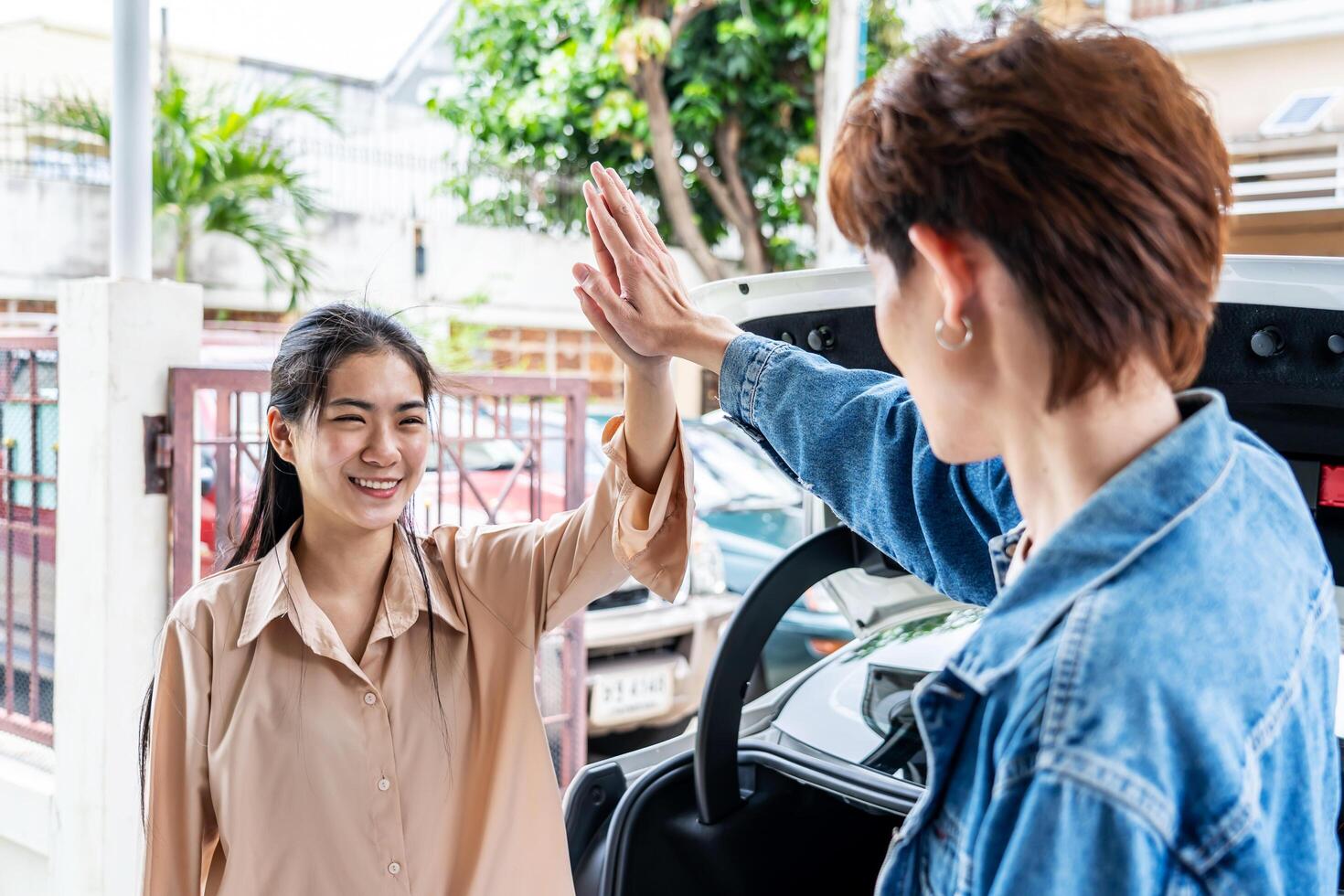 Happy asian young couple holding hands, standing against the background of a white car with Luggage for outdoor recreation, Concept of the man and woman is ready for travel. photo