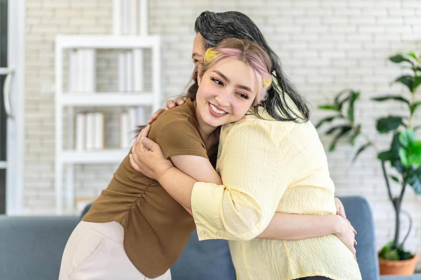 Happy asian senior mother and young daughter standing and hugging close up, smiling woman embracing older mum, spending leisure time together, two generations good relationship, fun photo