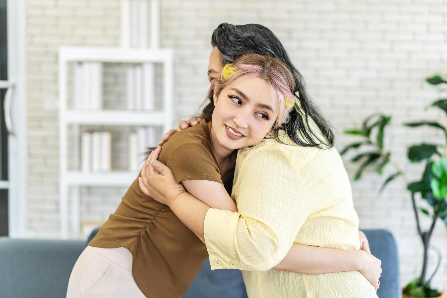 Happy asian senior mother and young daughter standing and hugging close up, smiling woman embracing older mum, spending leisure time together, two generations good relationship, fun photo