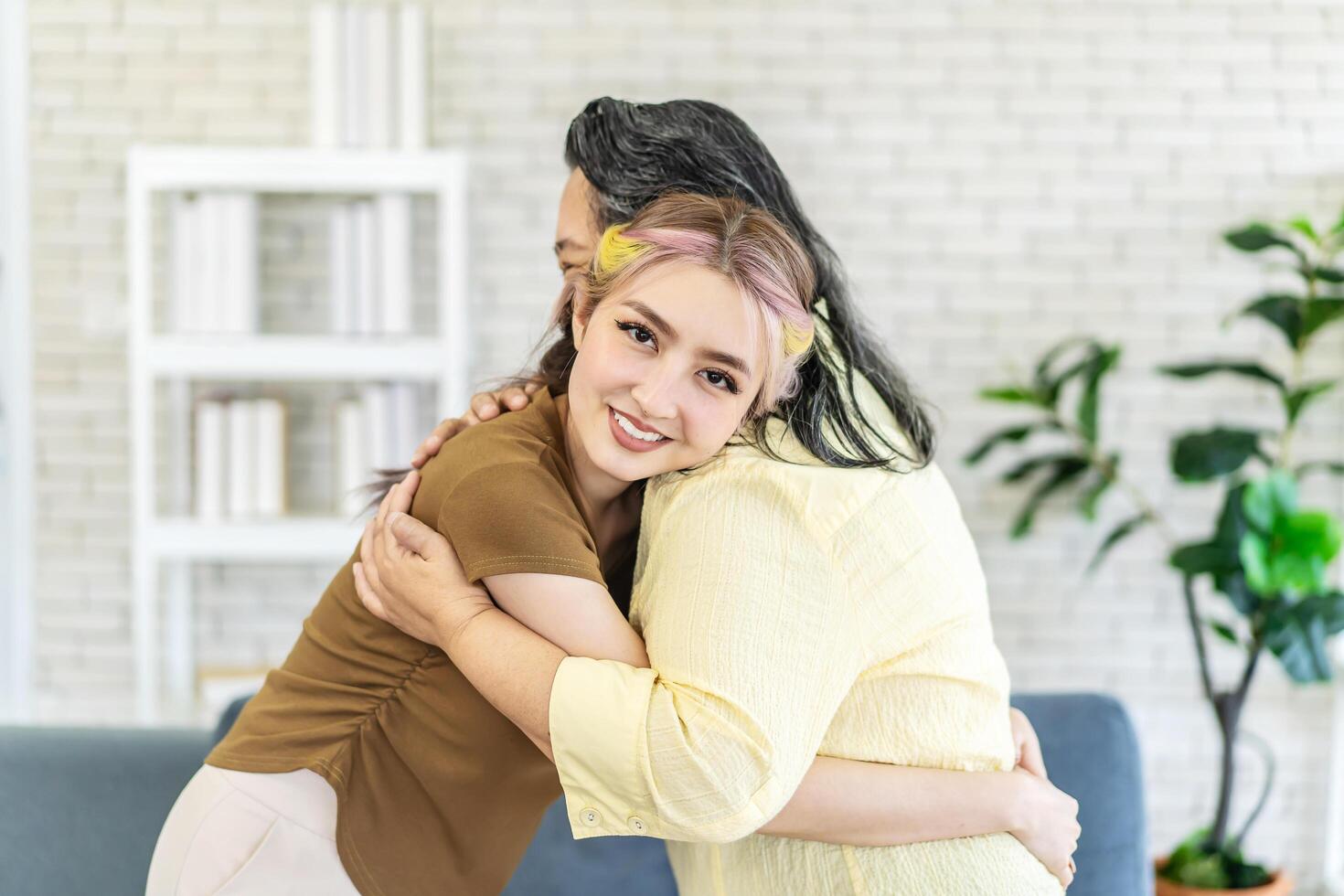 Happy asian senior mother and young daughter standing and hugging close up, smiling woman embracing older mum, spending leisure time together, two generations good relationship, fun photo