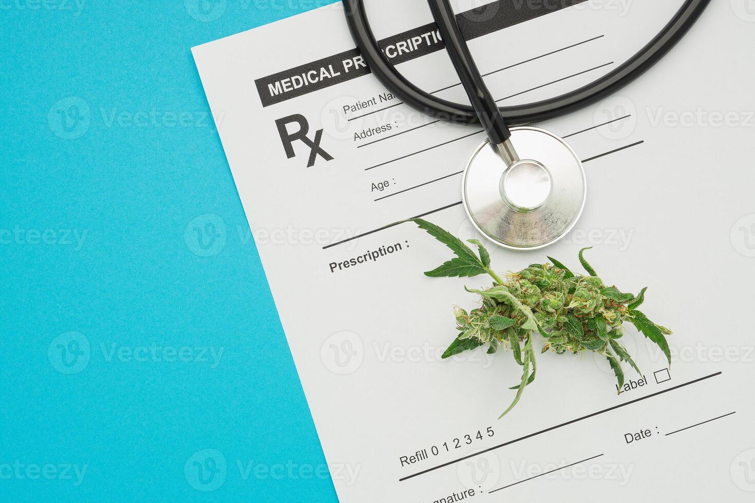 Top view of a stethoscope and marijuana buds flowers over on the medical prescription sheet isolated on a blue background photo