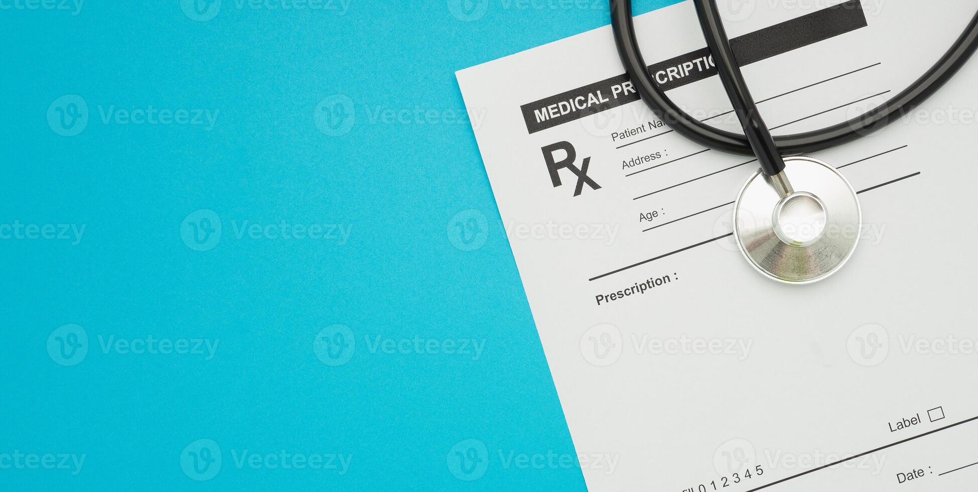 Top view of a stethoscope over on the medical prescription sheet isolated on a blue background photo
