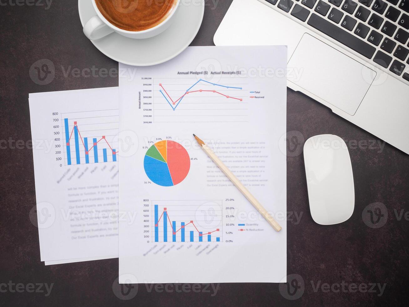 Top view of paperwork, laptop, mouse, and a coffee cup on the desk in the office. Business and strategy concept photo