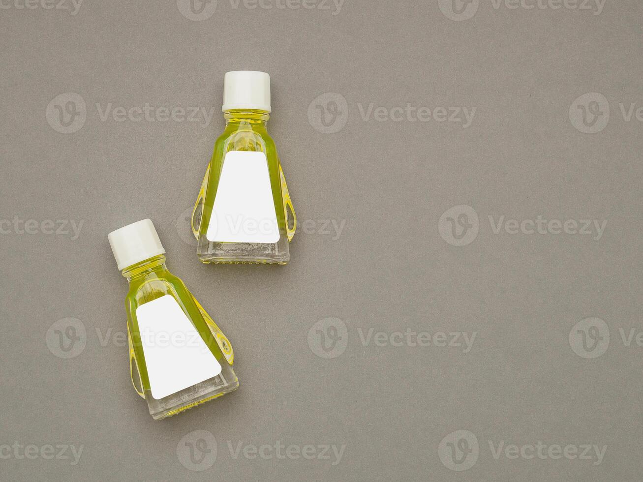 Small bottle containers with yellow herbal. Blank label for branding mockup. Natural beauty and health product concept photo