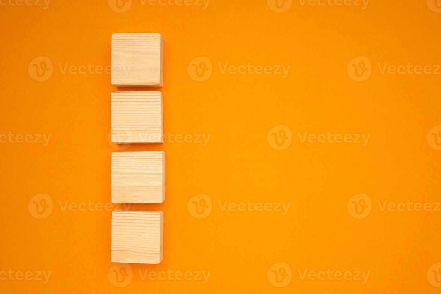 Top view of blank four wooden cubes on a yellow background with space for text photo