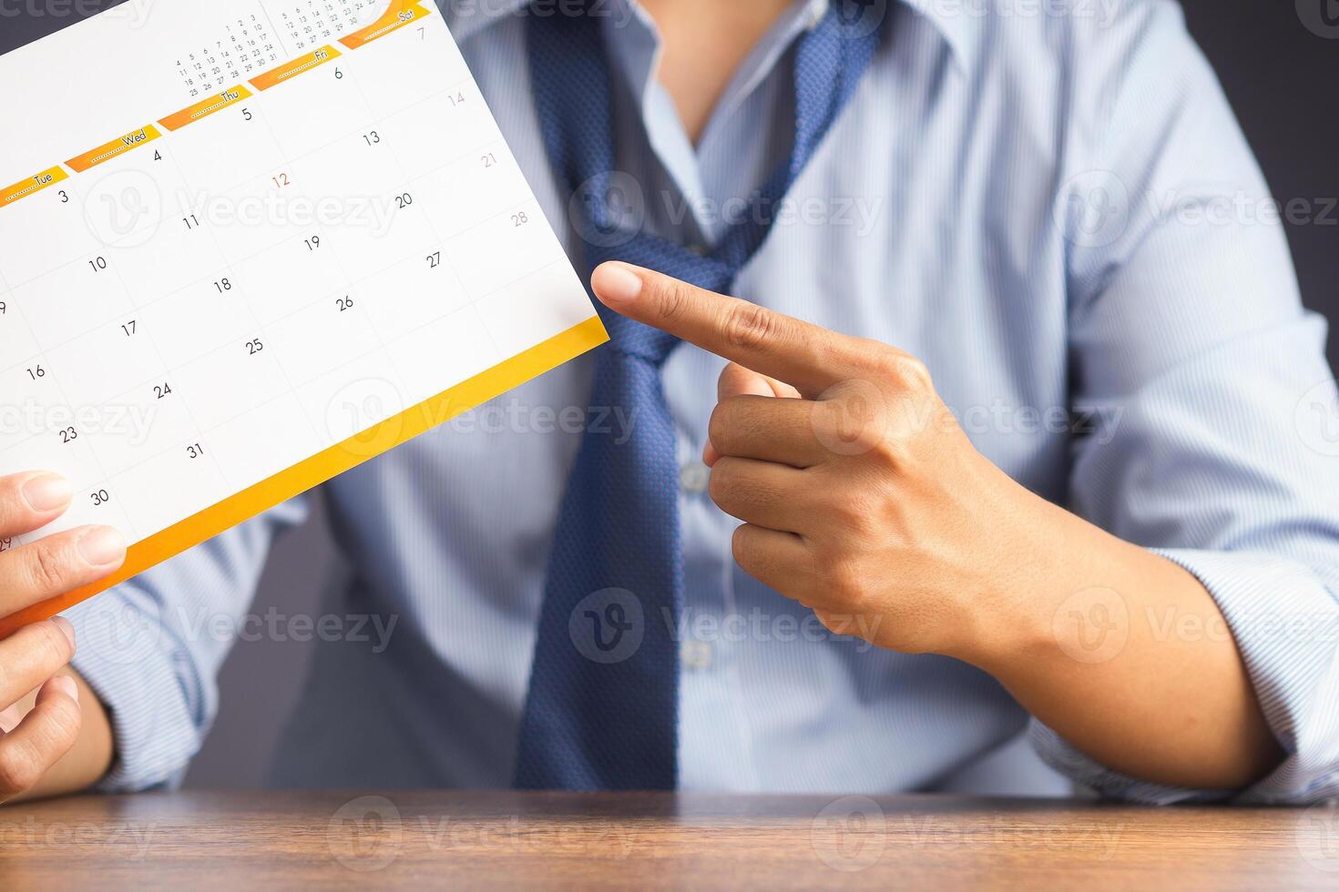 Planning work and life balance in holiday concept. Close-up of hand a man's pointing to a calendar for planning holiday. Close-up photo