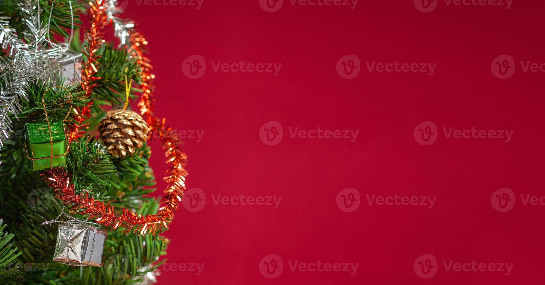 Part of Christmas tree over a red background with copy space for text photo