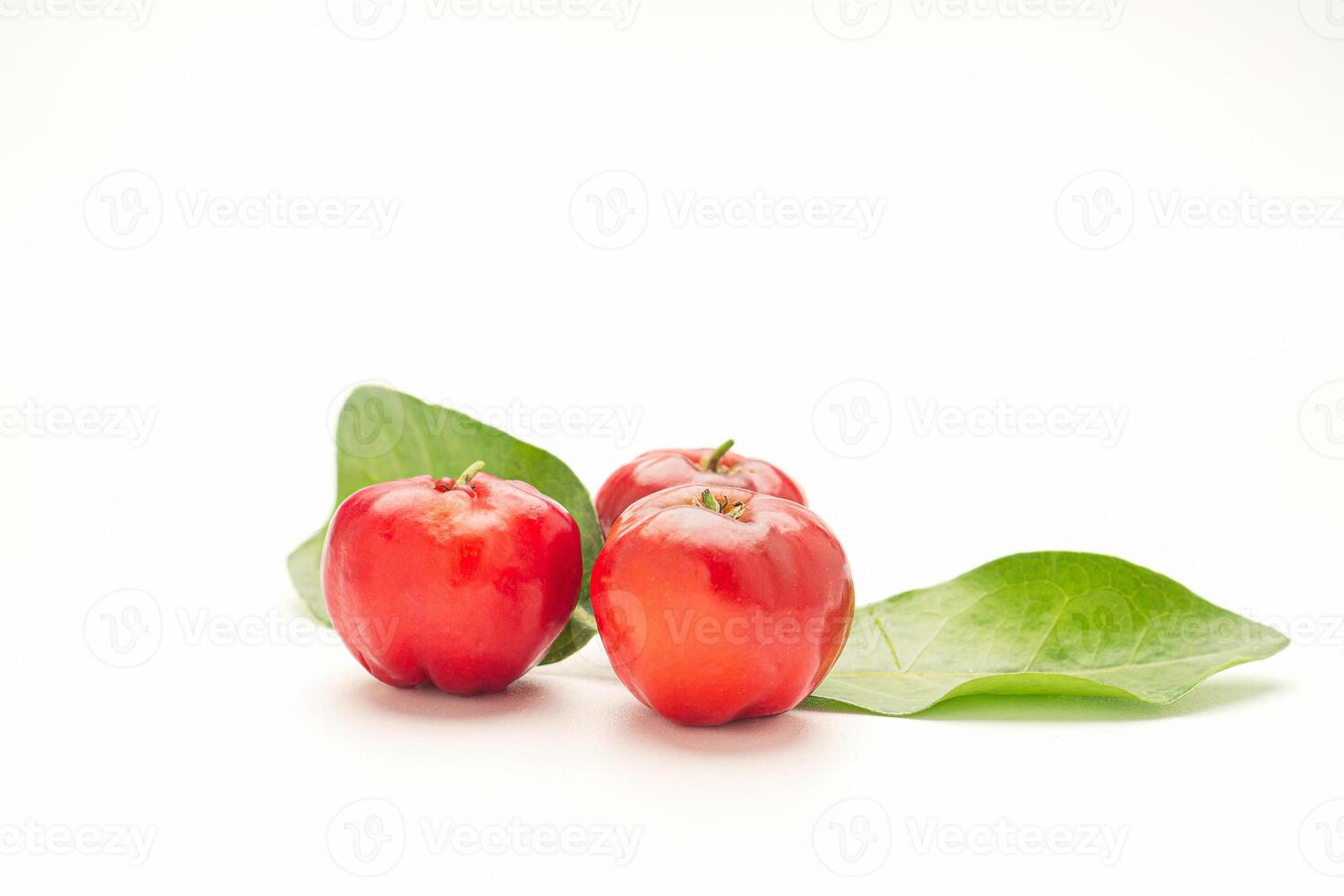 Ripe red acerola cherry fruit and green leaves isolated on white background. High vitamin C and antioxidant fruits. Top view. Space for text. Concept of healthy fruits photo