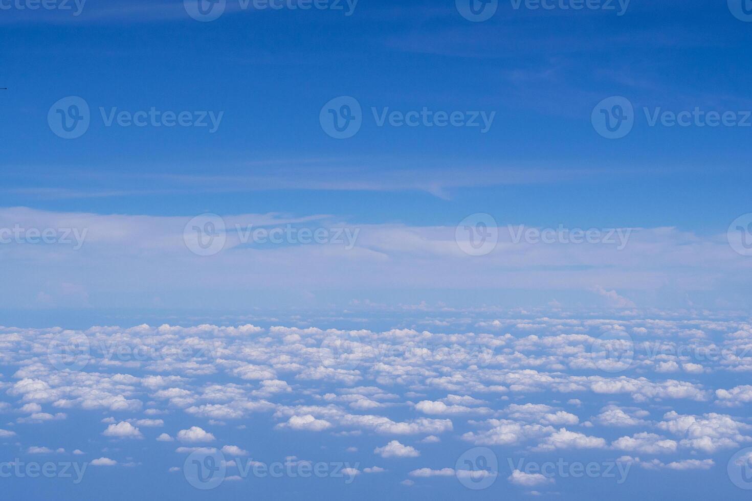 Aerial view of clouds and sky as seen through the window of an aircraft photo