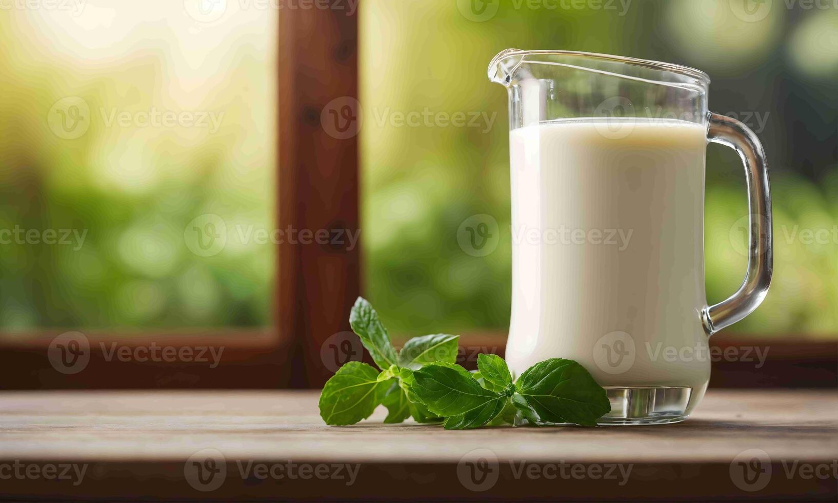 A pitcher of milk with mint leaves on a table photo