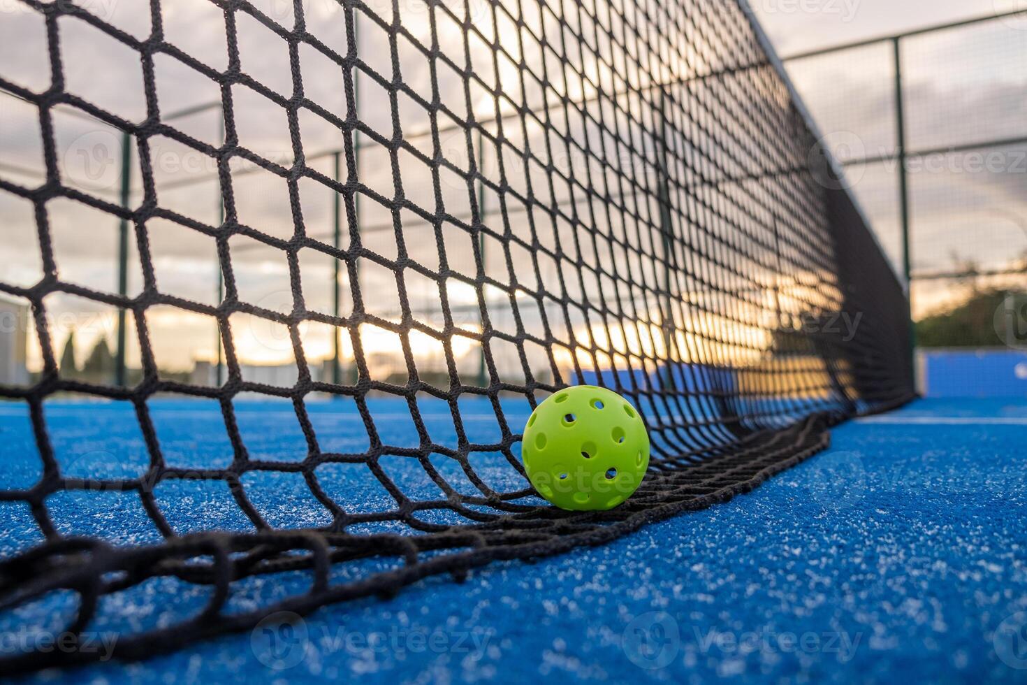 Selective focus. A pickleball ball on the net at sundown photo