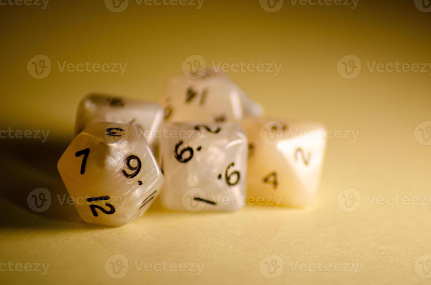 selective focus, five 12-sided white dice on yellow background dice for role-playing games photo