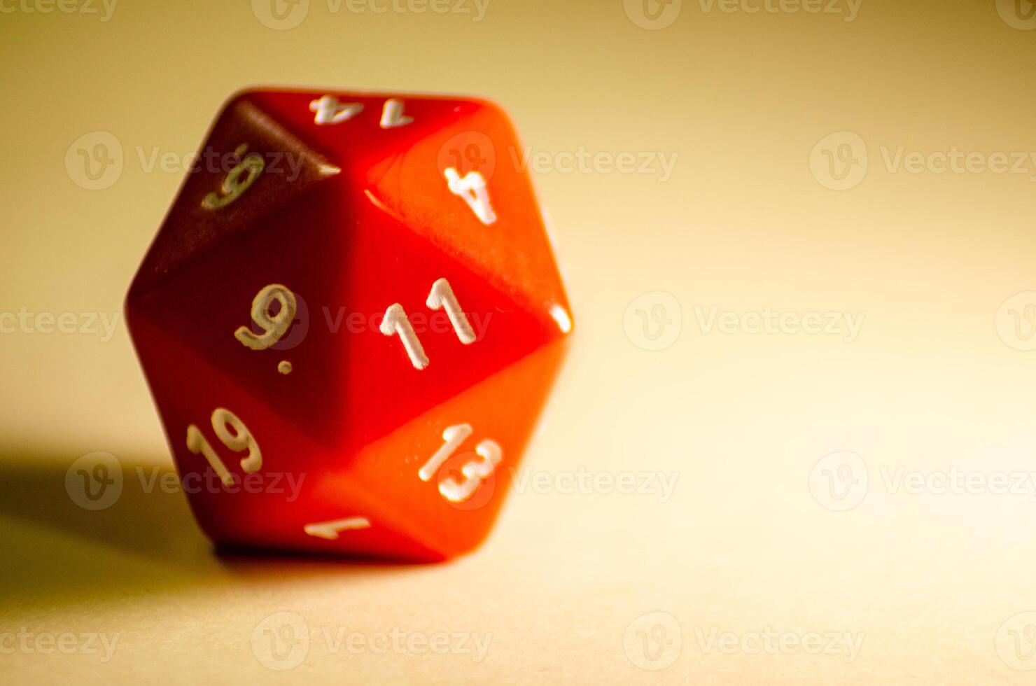 selective focus 20-sided red dice for role-playing game isolated on warm background photo