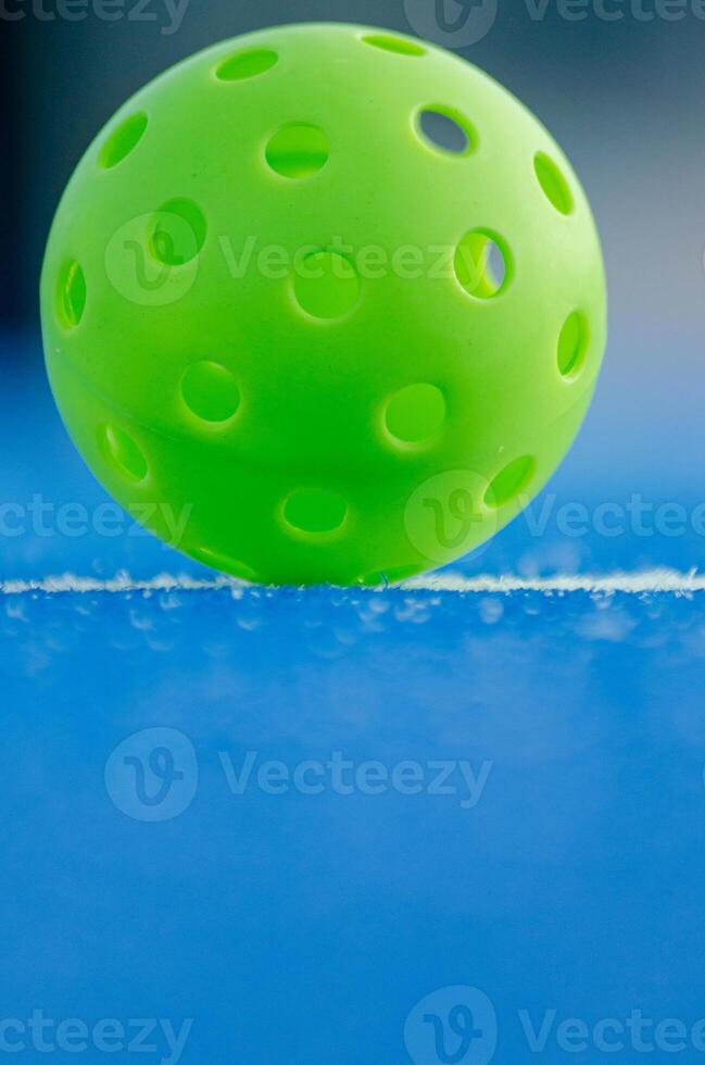Selective focus, a pickleball ball in a blue court. Racket sport photo