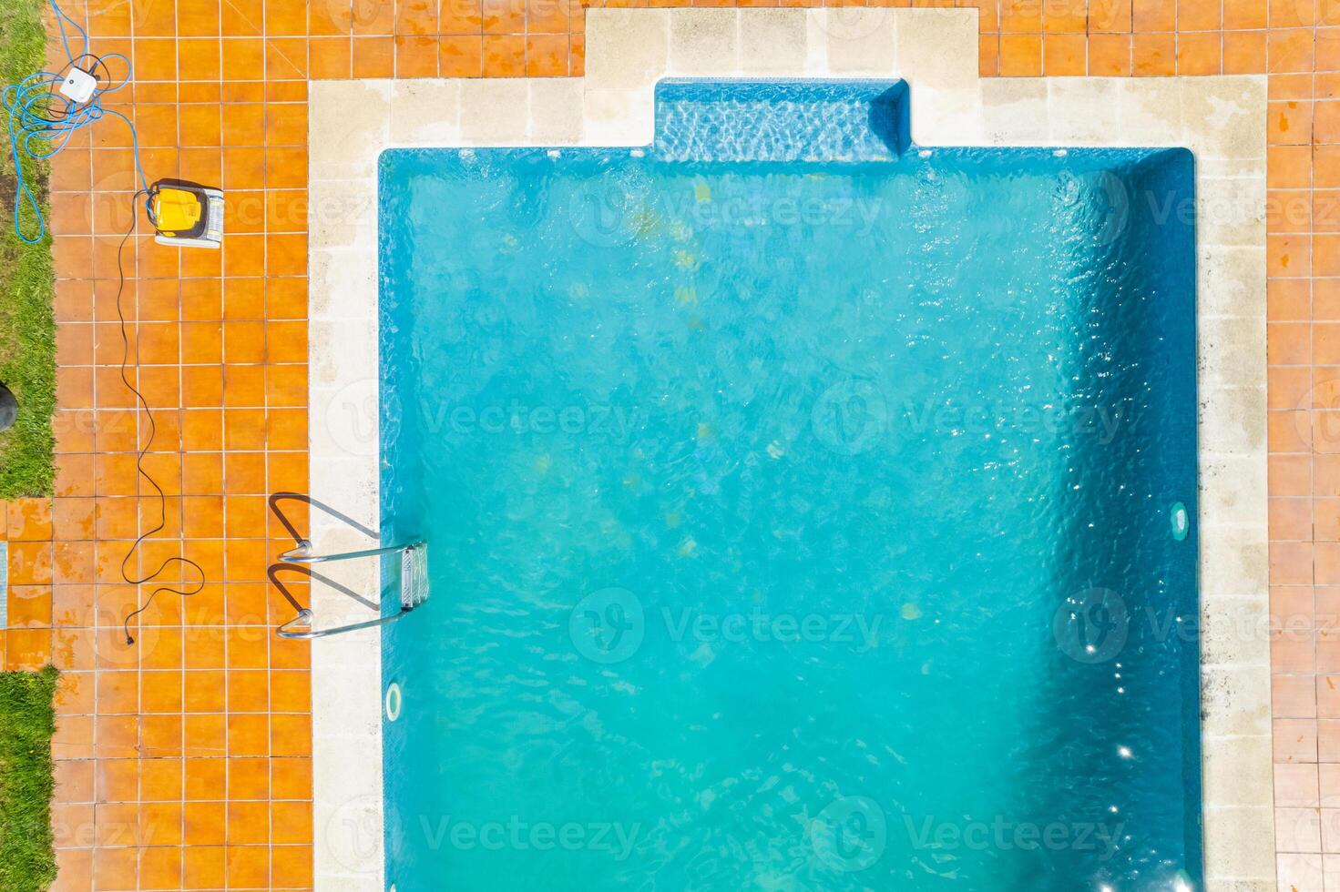 zenithal aerial view with drone of a swimming pool in summer with a pool cleaning robot photo