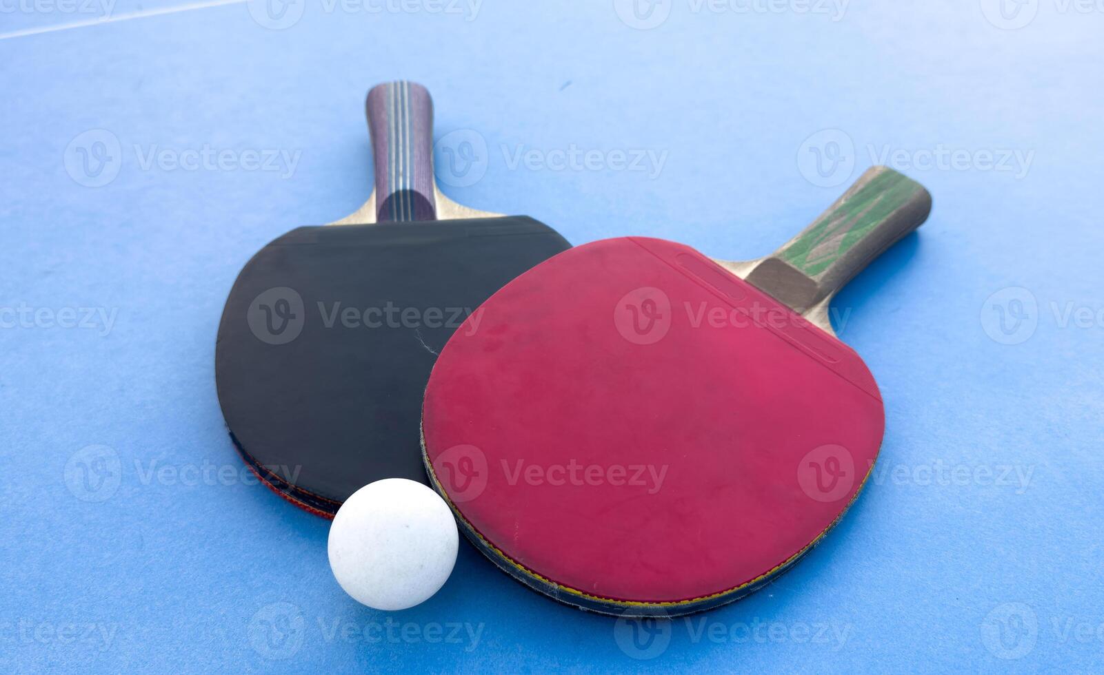 Table tennis bats and ball on a table with white vertical line. Concept of competition photo