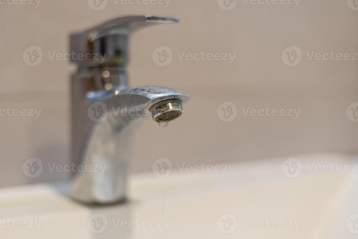 Leaking faucets or water-flowing faucets. On the toilet bowl, wash the dirty white face with damaged and old taps that have water all the time, causing depletion of water resources and money in vain. photo