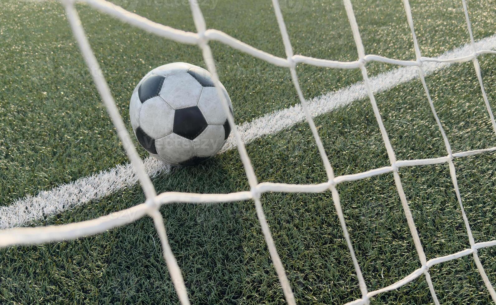 Soccer ball in goal on blue background photo