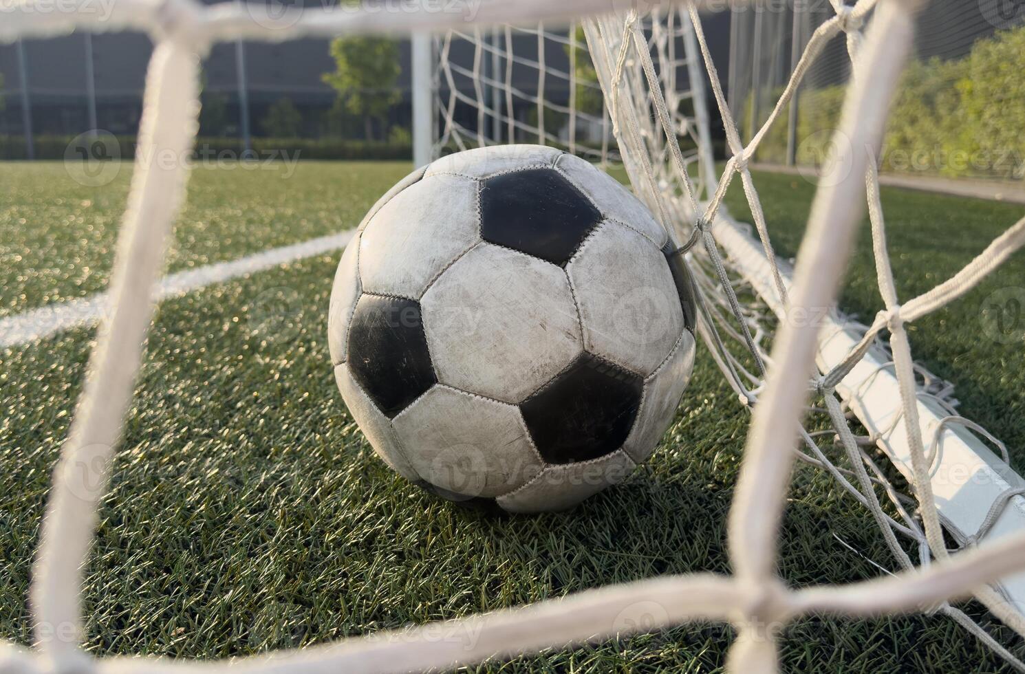 Soccer ball in goal on blue background photo