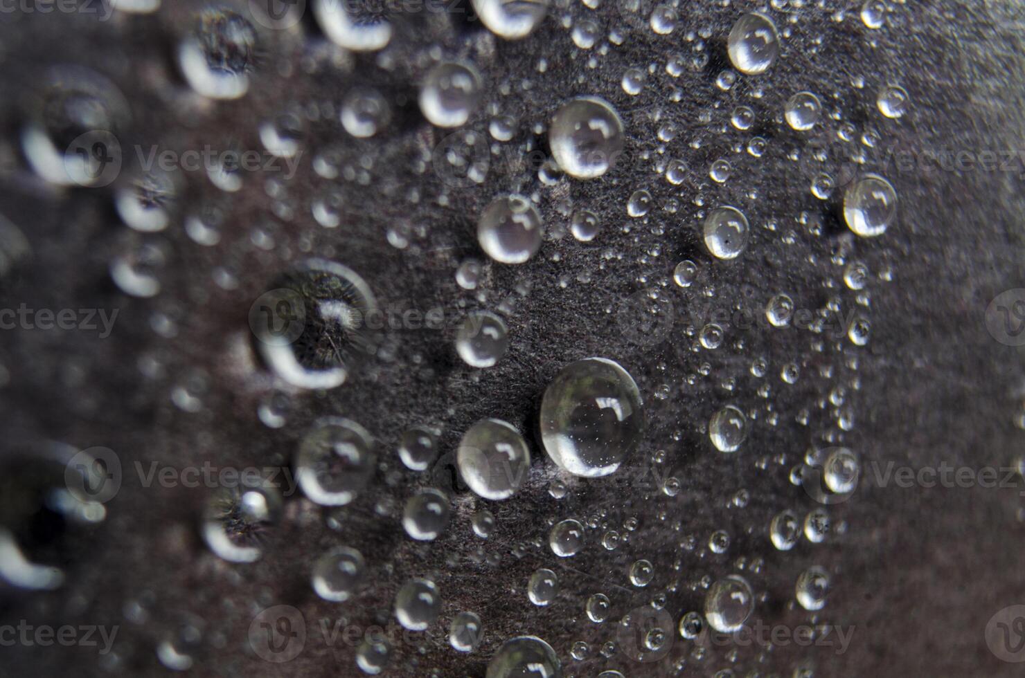 Close up or macro photography of water droplets on dark cover cover background. Water droplets and wallpaper concept photo