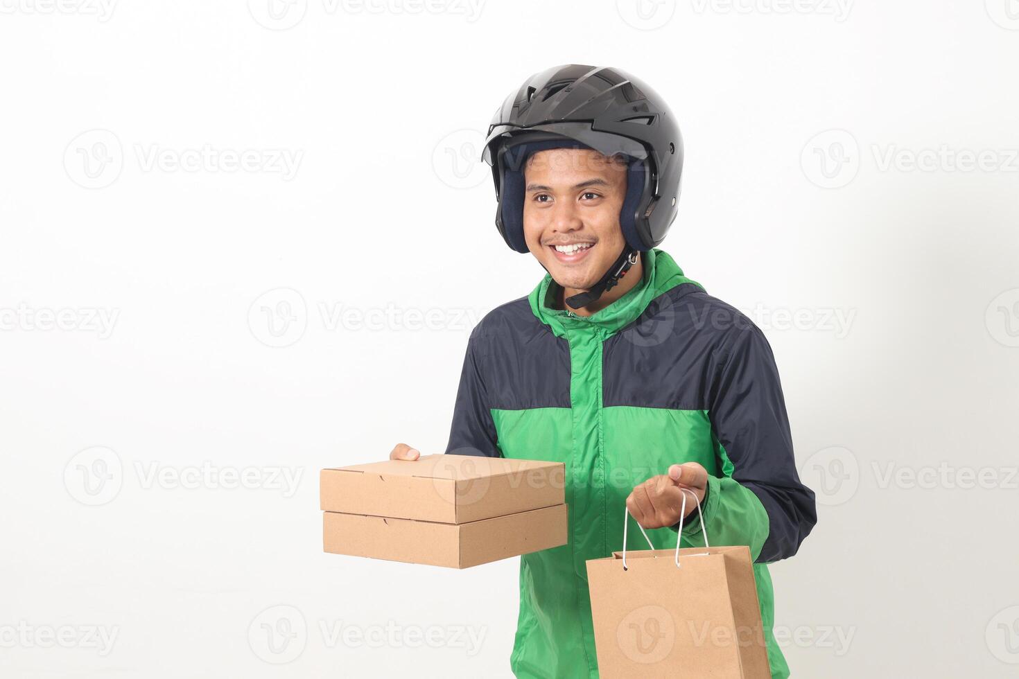 Portrait of Asian online courier driver wearing green jacket and helmet delivering package and box for customer. Isolated image on white background photo