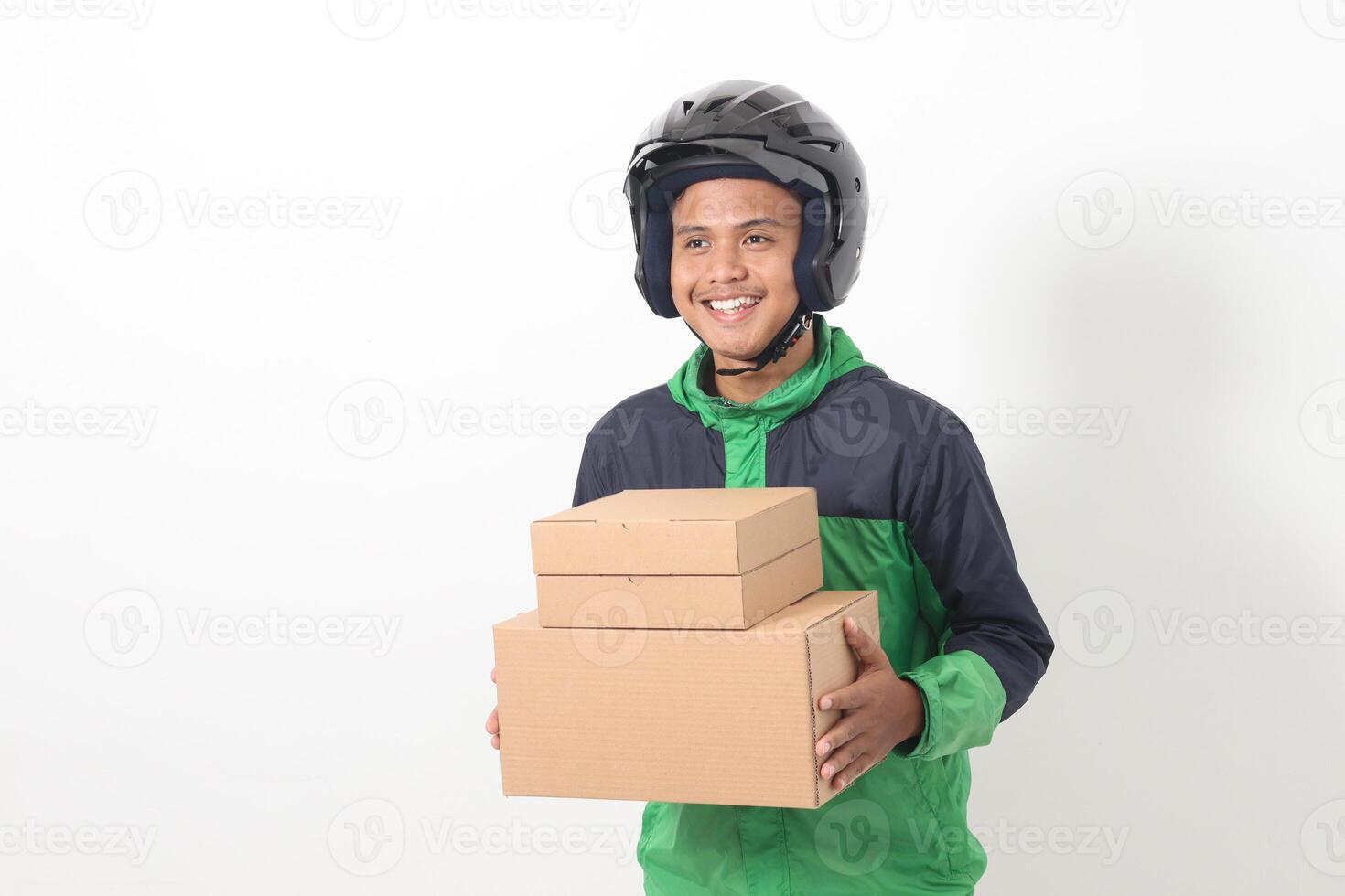 Portrait of Asian online courier driver wearing green jacket and helmet delivering package and box for customer. Isolated image on white background photo