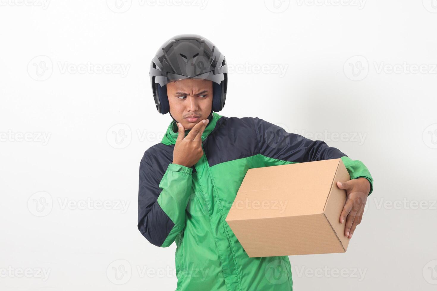 Portrait of Asian online courier driver wearing green jacket and helmet delivering package and box for customer. Isolated image on white background photo