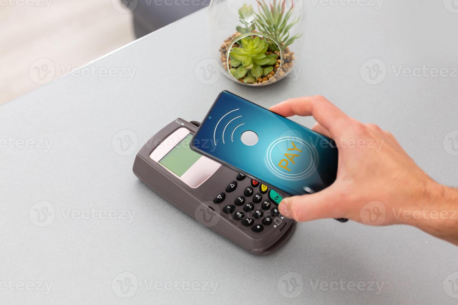 Customer using mobile phone to pay by NFC photo