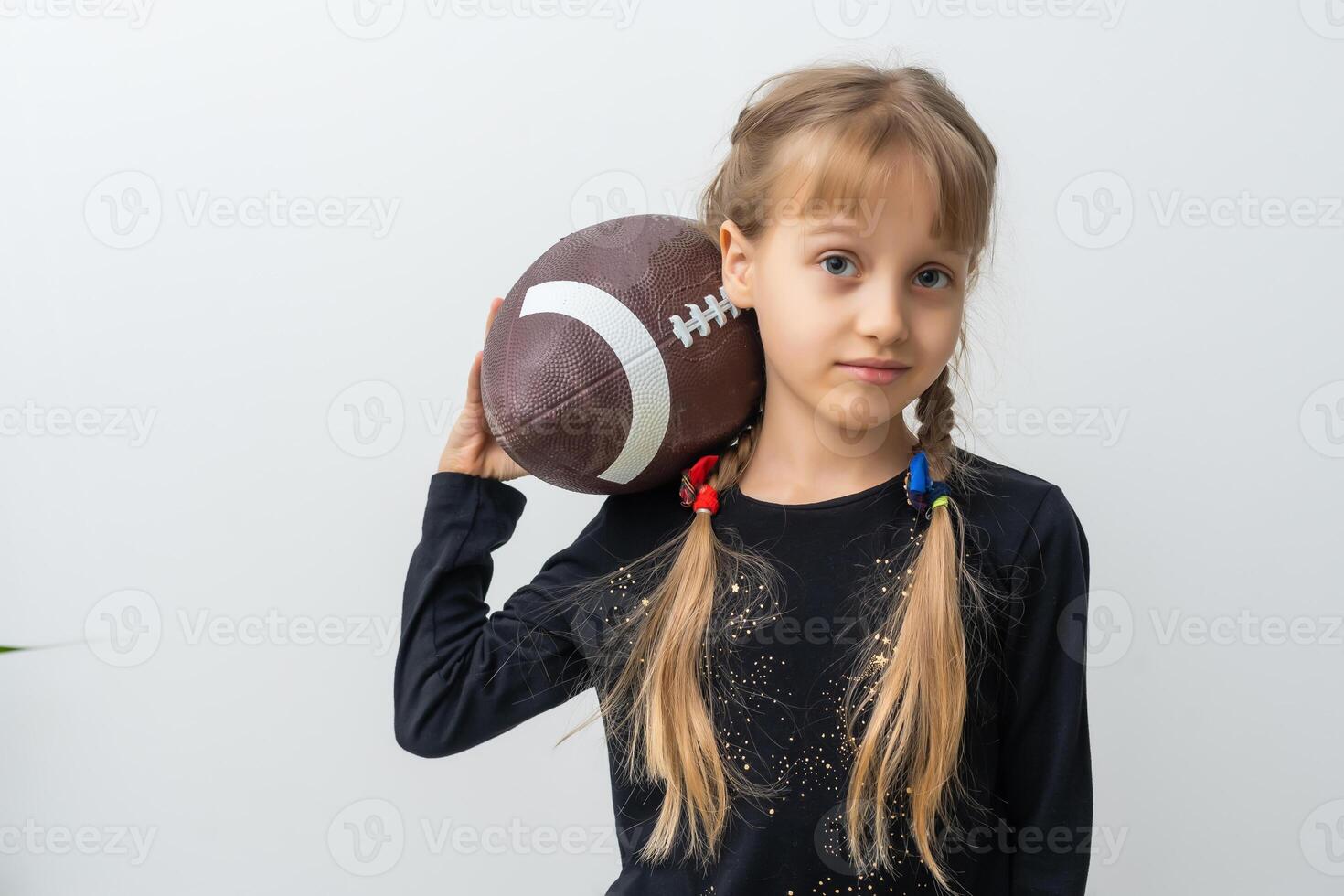 Little girl holding a rugby ball. photo