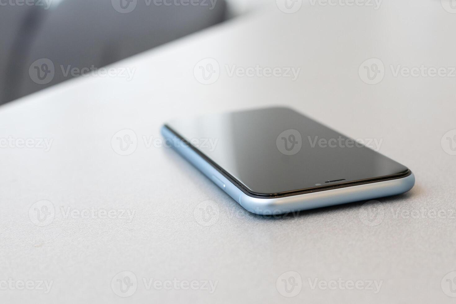 modern mobile phone with blank screen on black stone table background. Smartphone on old dark grey vintage texture background. photo