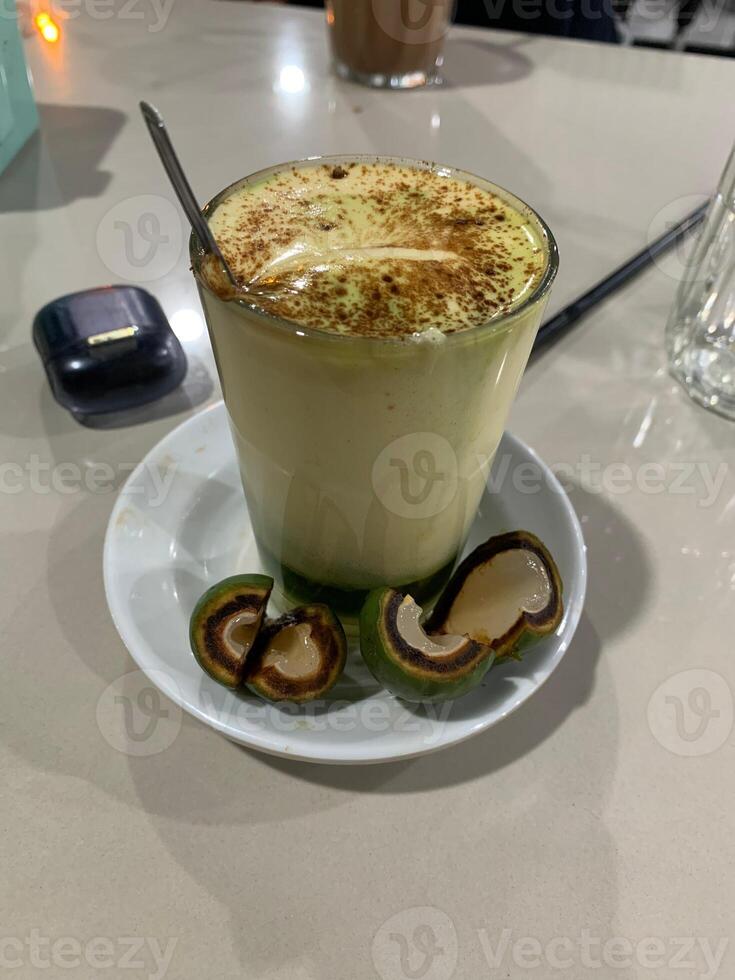 A Glass of Creamy Drink with Cinnamon and Betel Nut Halves photo