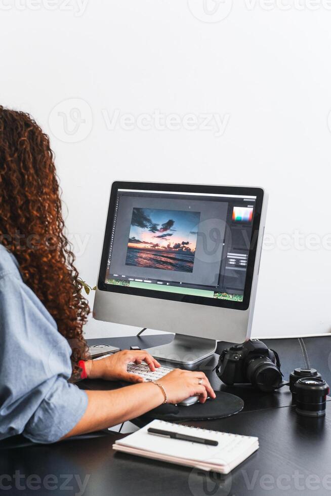 Female photographer editing a photo on a computer.
