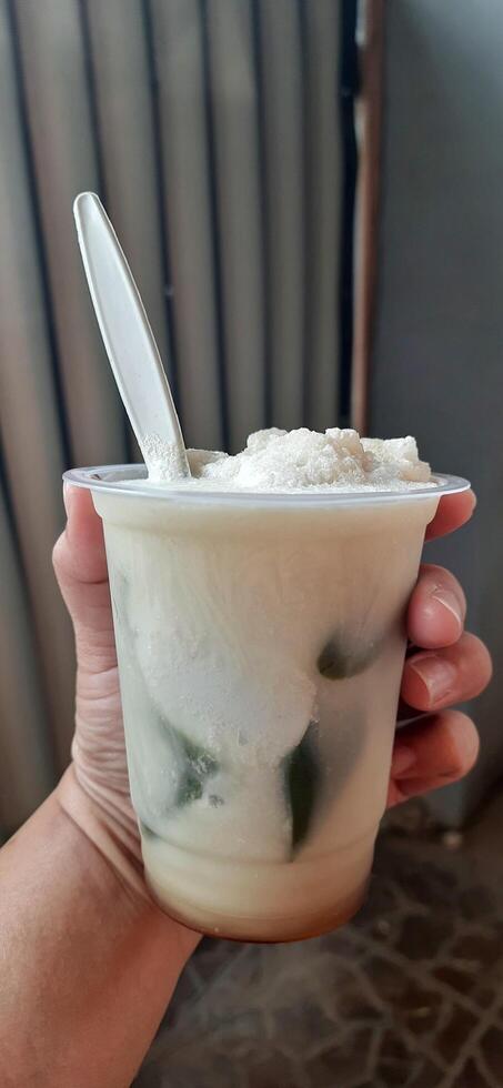 Es Cincau Hijau or Green Grass Jelly dessert. Indonesian traditional drink made from grass jelly, coconut milk and palm sugar syrup photo