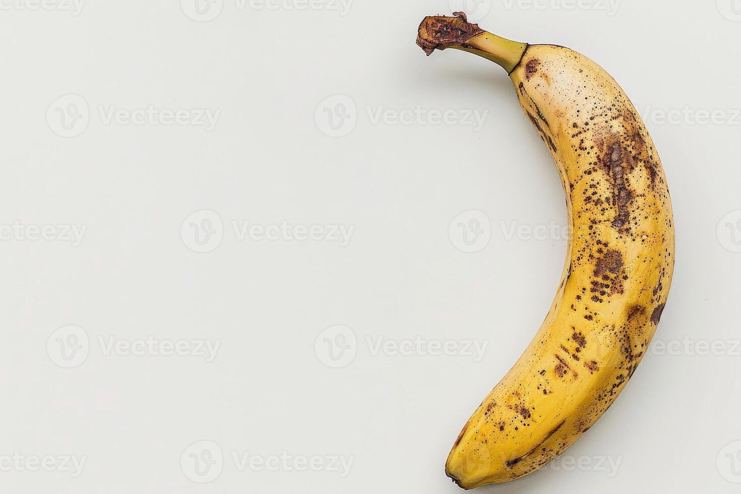 A banana is shown on a white surface photo