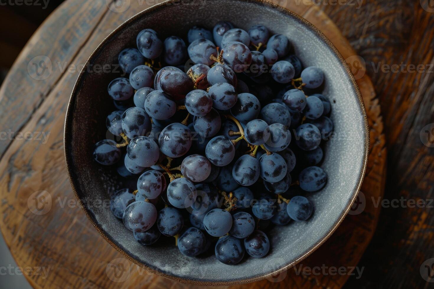 A bowl of grapes on a wooden table photo