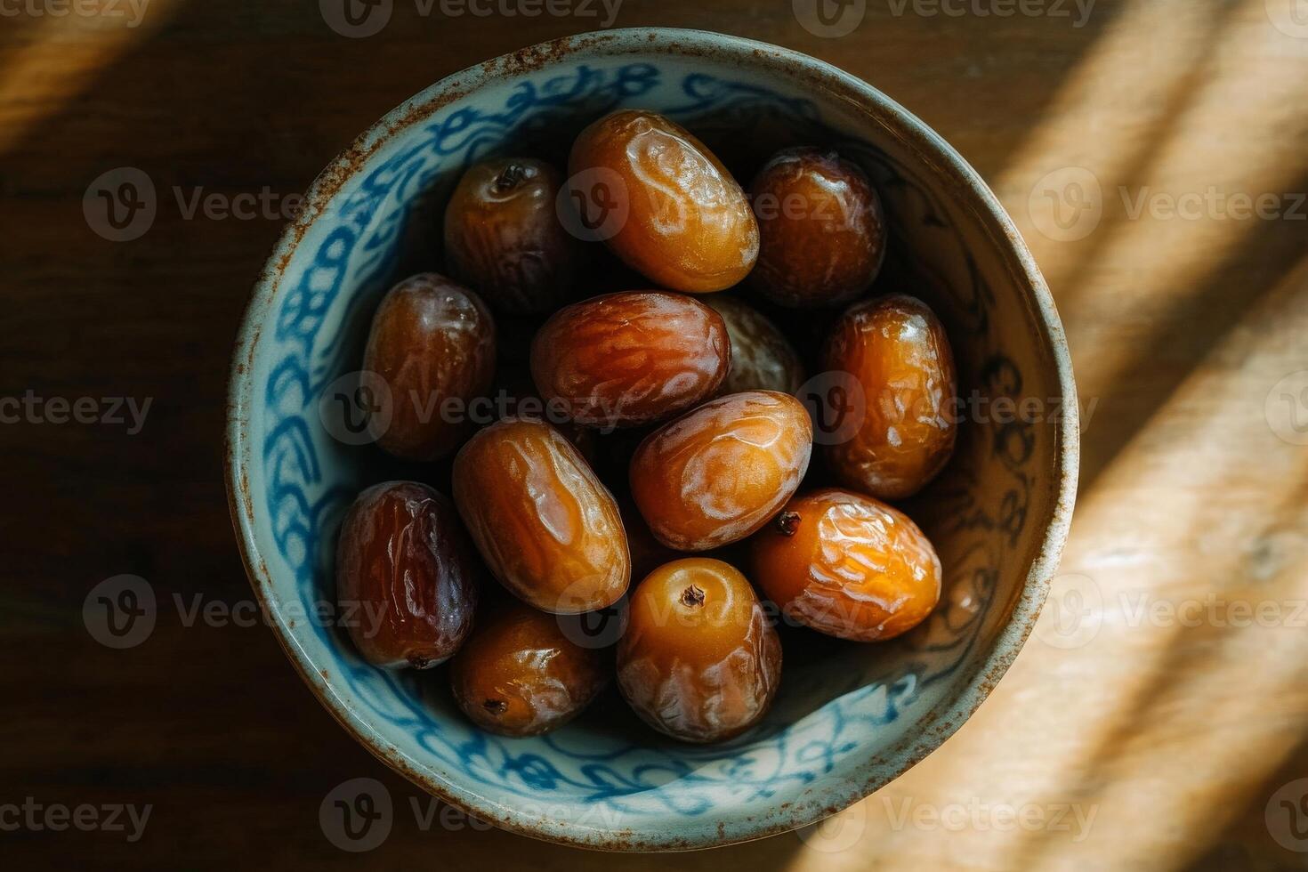 A bowl of dates on a wooden table photo
