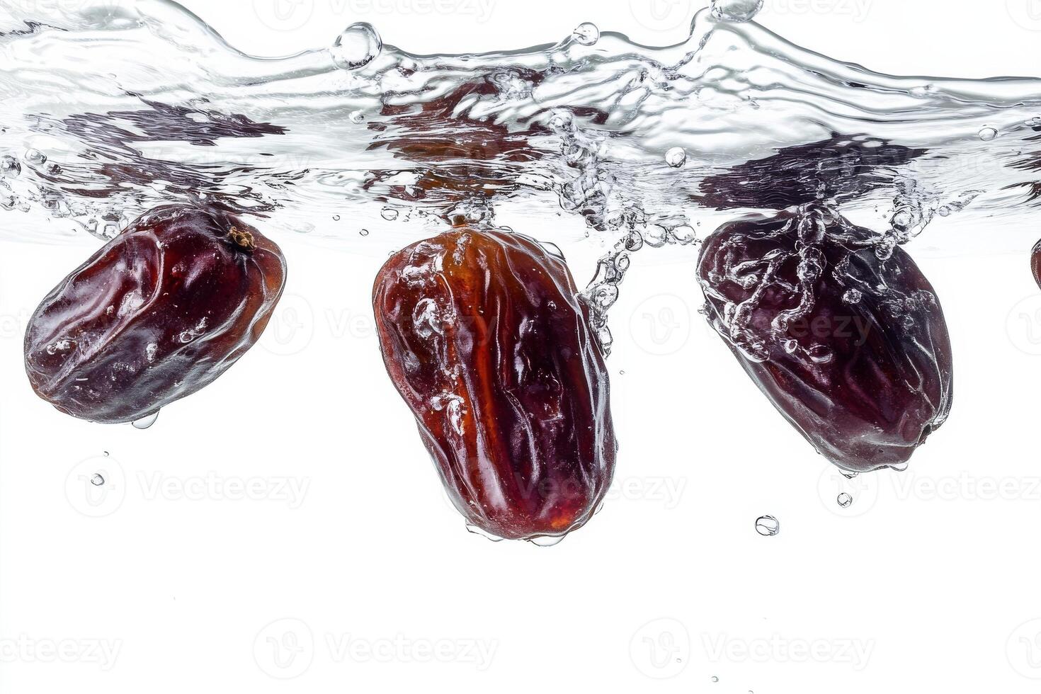 Dates falling into water on a white background photo