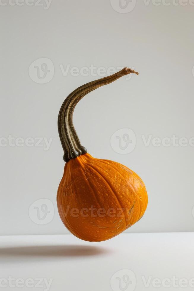 A pumpkin is floating in the air on a white surface photo