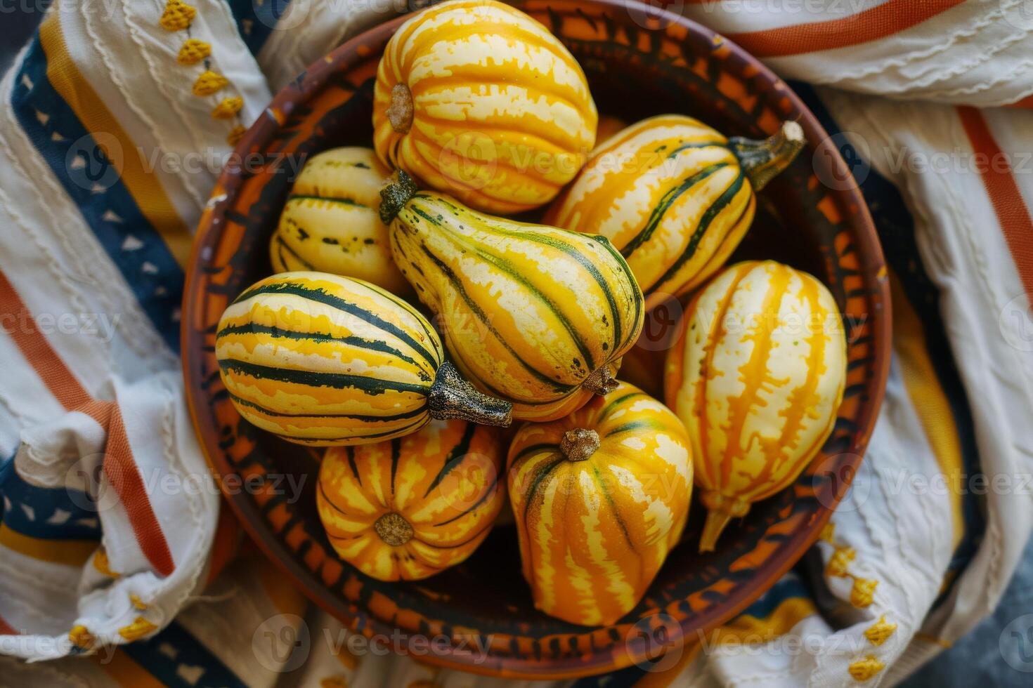 A bowl of yellow and green squash sitting on a table photo