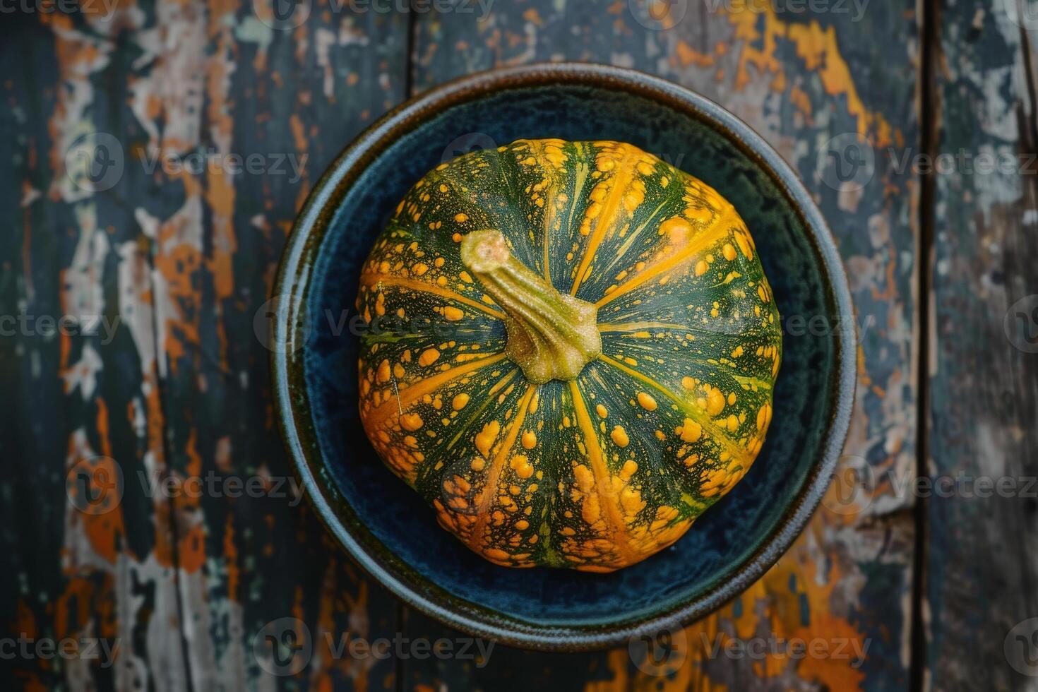 A green and yellow squash in a bowl on a wooden table photo