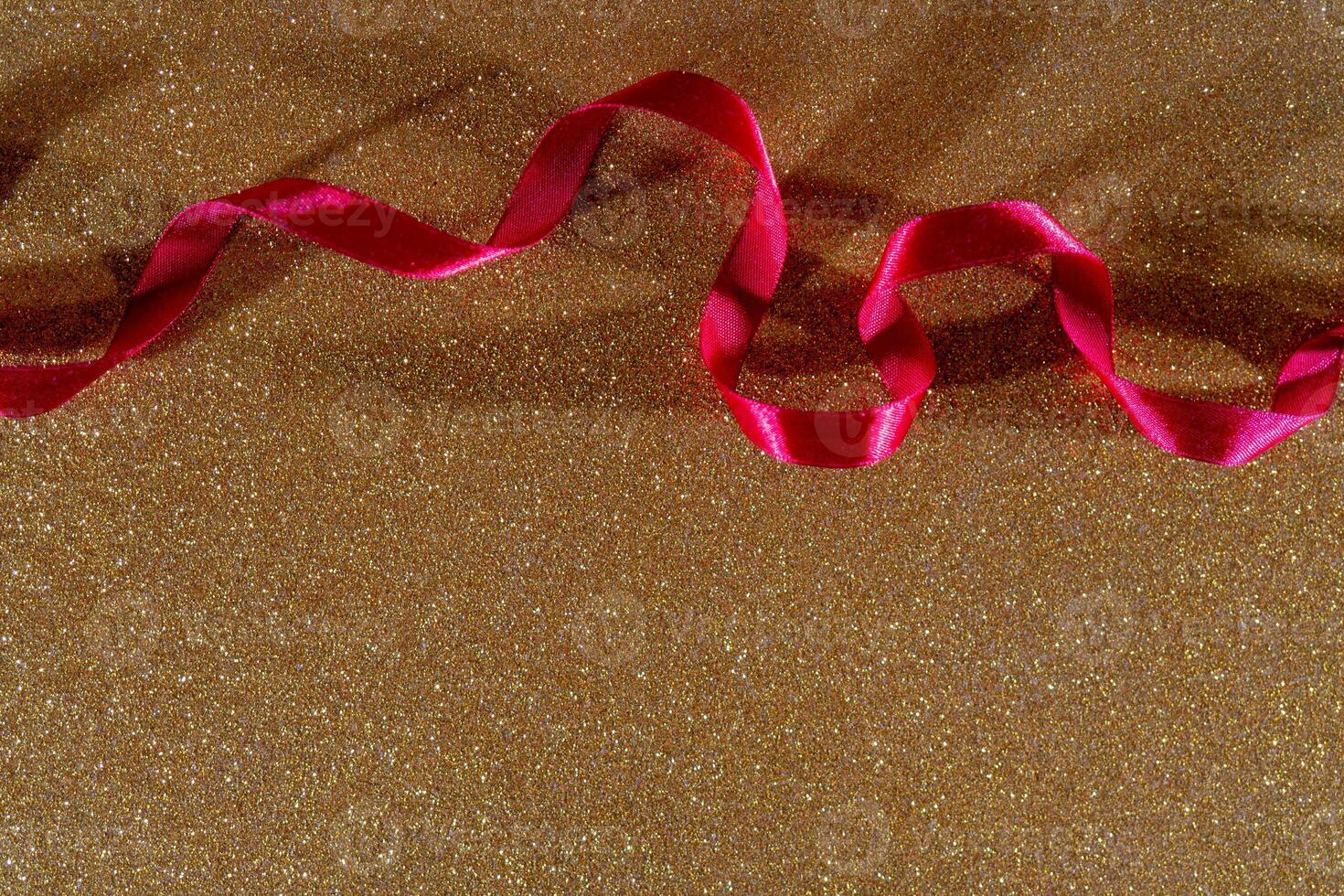 Red wavy ribbon on gold background. Holiday decoration. Valentine's Day decoration congratulation frame. photo