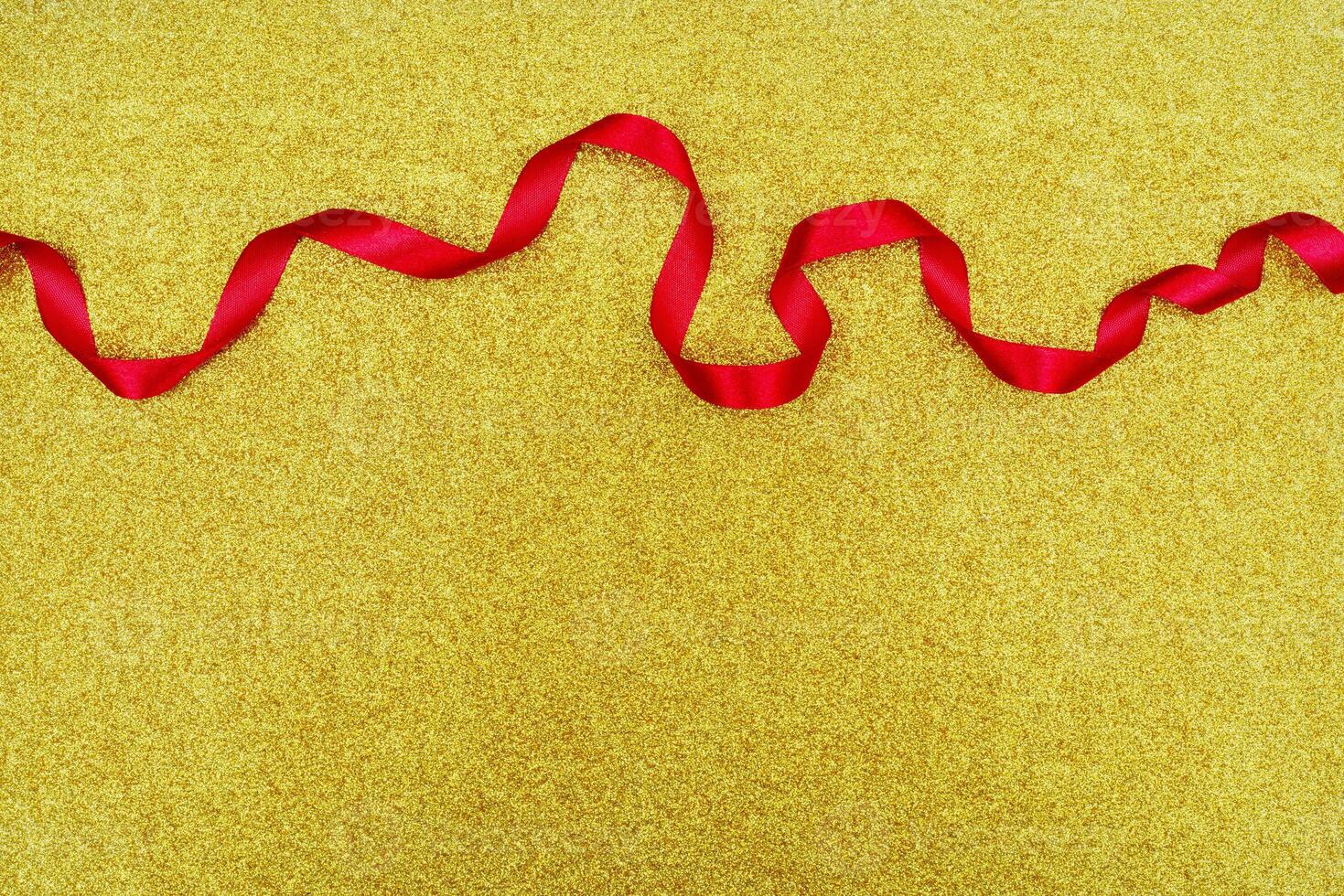 Red wavy ribbon on gold background. Holiday decoration. Valentine's Day decoration congratulation frame. photo