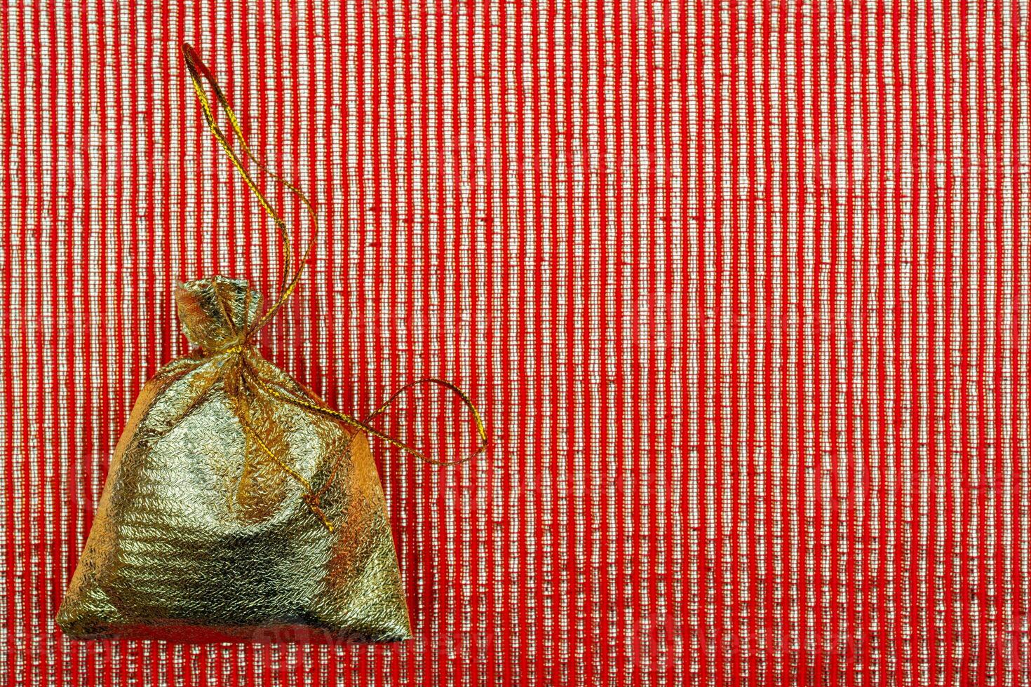 Shiny golden pouch on a red background. A gift on a holiday. photo