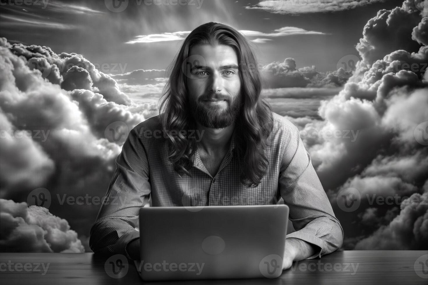 A man with a beard is sitting at a table with a laptop and a cup of coffee. He is focused on his work, possibly typing or browsing the internet. Concept of productivity and concentration. photo