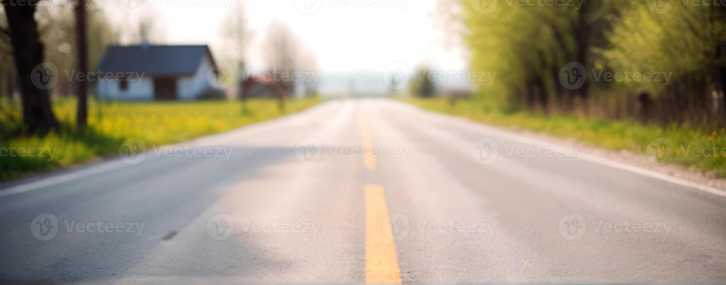 A blurry image of an empty road with trees in the background photo