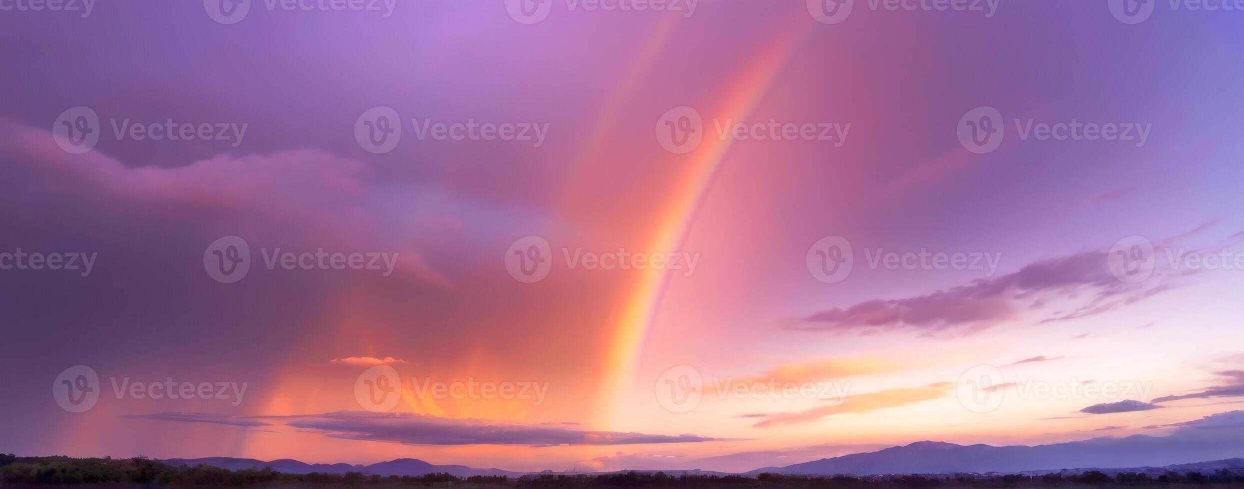 A rainbow is seen over the mountains at sunset photo