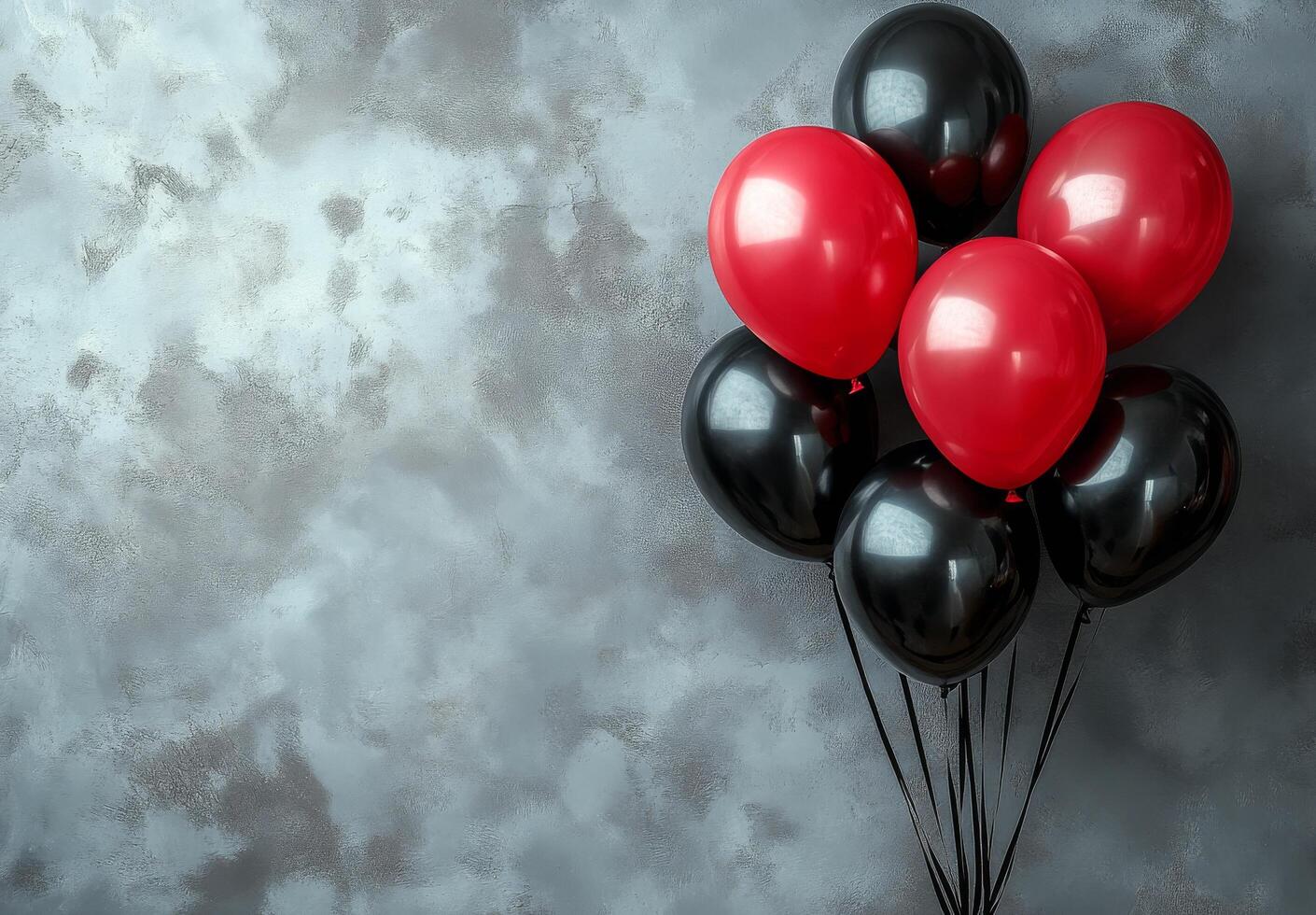 Colorful black and red balloons tied together against a light gray background photo